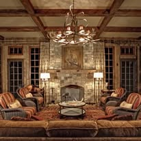 Great room with beamed ceiling, stone fireplace, and chandelier