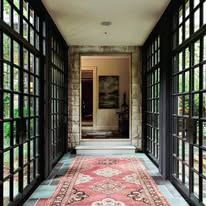 Glass-walled gallery corridor with patterned rug