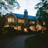 Stone manor residence illuminated at dusk