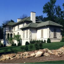 Stucco residence with tile roof and landscaped grounds