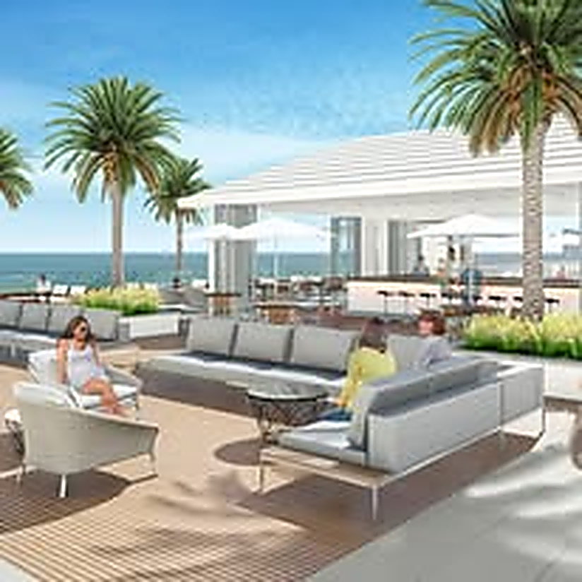 Oceanfront rooftop lounge with palm trees and open-air seating